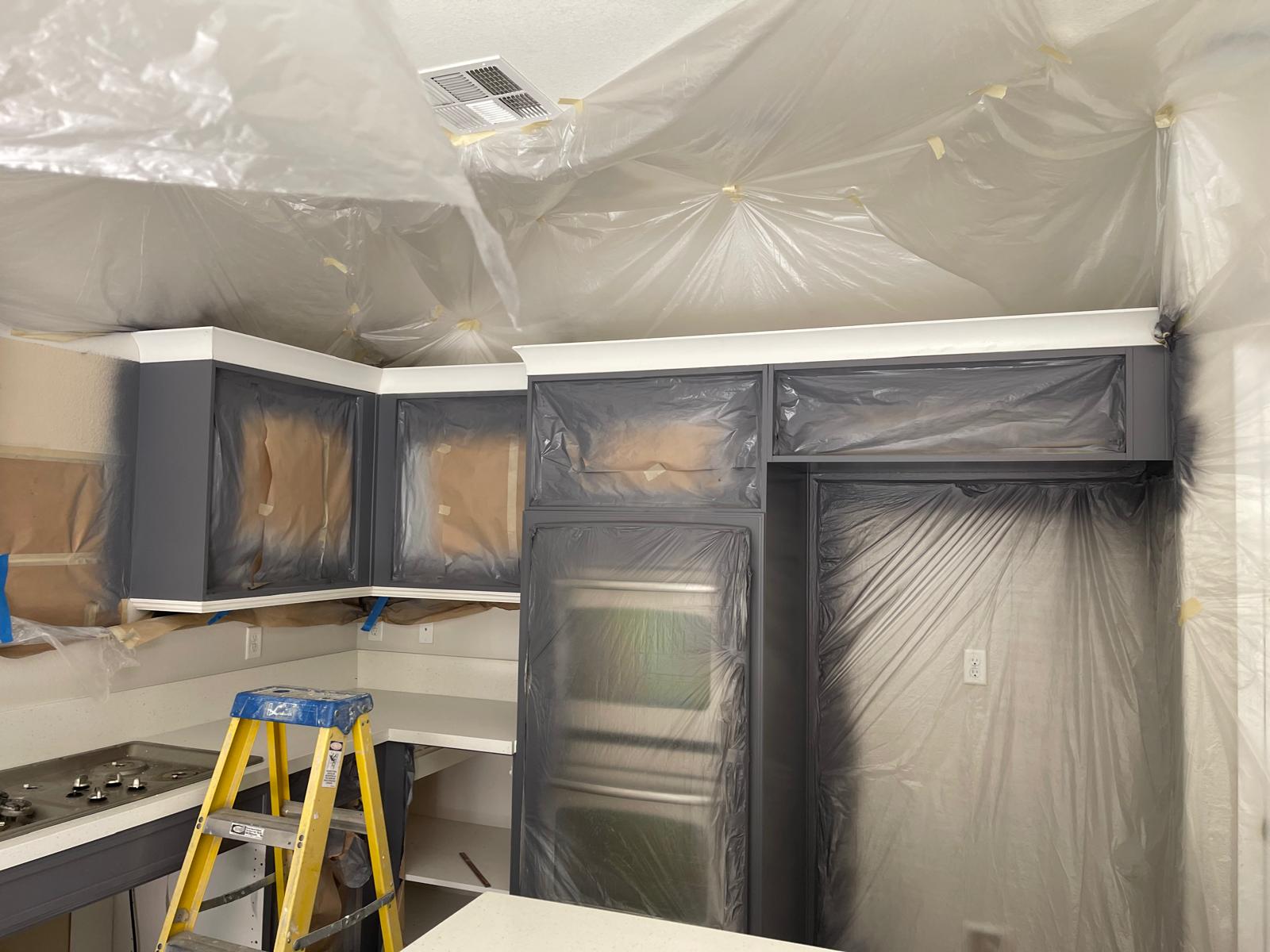 Kitchen cabinets before repaint, masked for painting